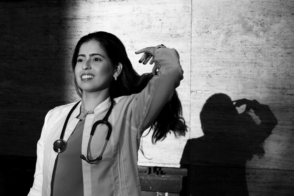 Black and white portrait of a smiling medical student posing with a stethoscope in Buenos Aires.